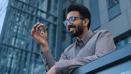 Smiling man Indian Arabian businessman real estate agent business investor hold bunch of keys new...
