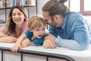 Obraz premium Family enjoys quality time together indoors in a cozy setting while engaging with a child