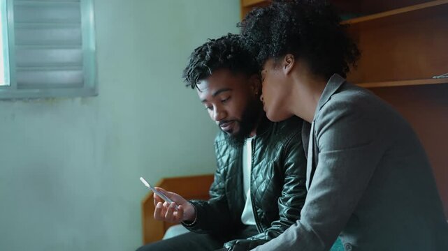 Young woman wanting partner's attention while he looks at cellphone device, boyfriend engrossed by social media entertainment while girlfriend wants attention, sharing screen