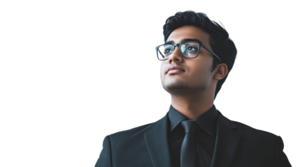 A young man in a formal suit and glasses looking upwards thoughtfully, showcasing ambition and determination against a white isolated background.