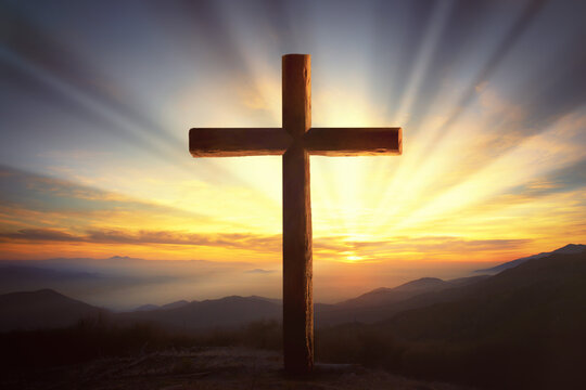 Wooden crucifix in a mountain landscape at sunset