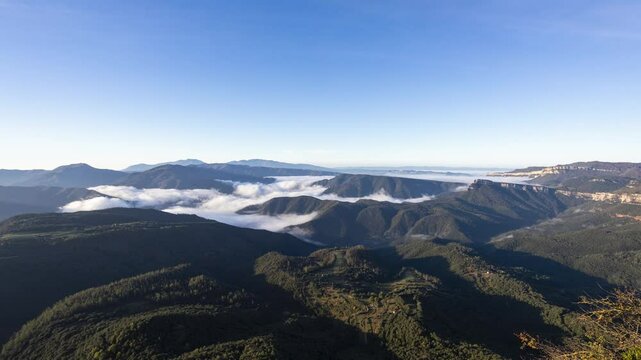 Clouds timelapse over forested mountains and blue sky in Osona, Barcelona, Spain