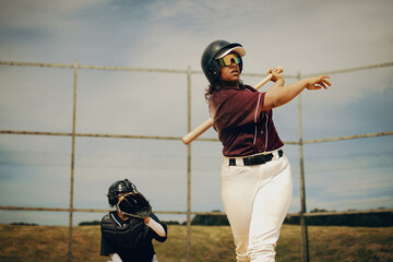 Baseball player hits a grand slam during a game on a bright, sunny day
