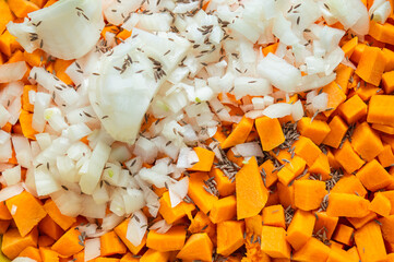 Pumpkin cubes and onion in spices. texture of diced pumpkin with onions and spices for filling...