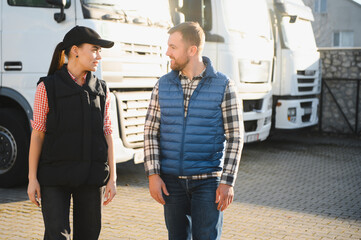 A woman and a man work as truck drivers. The concept of logistics and cargo delivery. In the...