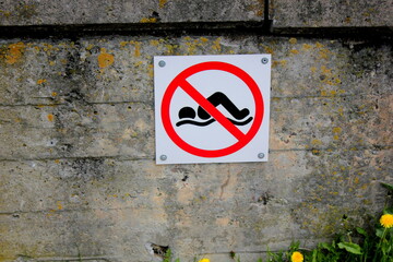 no swimming sign on the city street wall