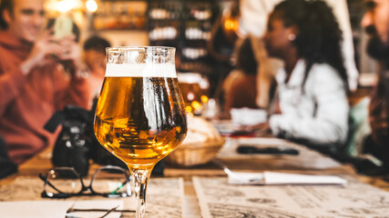 Group of people having lunch at brewery bar restaurant - Close up glass beer on dining table - Brewery and food concept