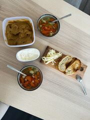 Healthy homemade meal with soup, salad, and bread on a wooden table setting