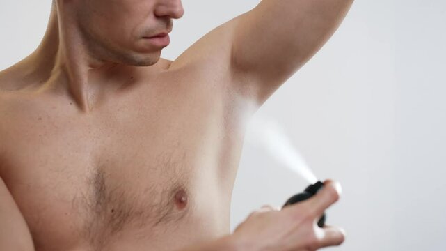 Man using deodorant on his armpits