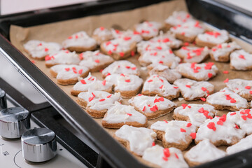 woman making heart shaped cookies in the kitchen, adding heart sprinkles