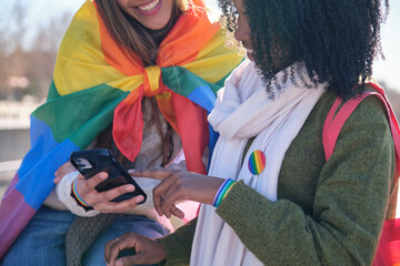 Two friends showing support for lgbt community using rainbow flag and bracelet, sharing content on...