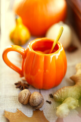Pumpkin cup with hot natural tea with  lemon. Healthy drinks in autumn.    