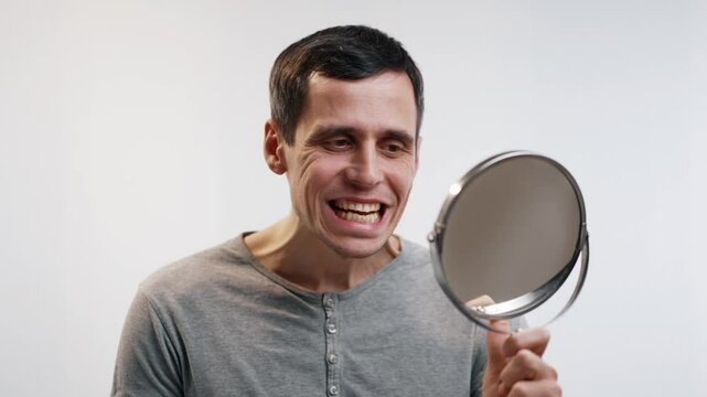 Man inspecting his teeth in the mirror