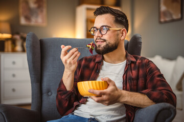 adult man sit at armchair and eat salad healthy lifestyle concept
