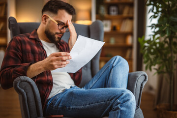 shocked and angry man sit and read document with a bad news
