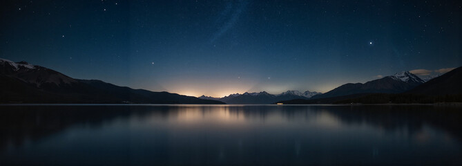 Serene mountain lake at night with starry sky