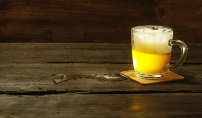 Light beer in a glass goblet, wooden table