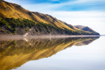 The beautiful banks of the Siberian river Lena are reflected in the water