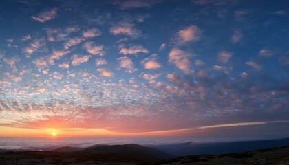Obraz premium a wispy layer of altostratus clouds is visible across the sky as the sun rises over the horizon with soft pink light soft focus sunrise