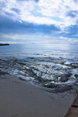 Fototapeta premium ゴツゴツした岩の潮溜りと透き通った青い海