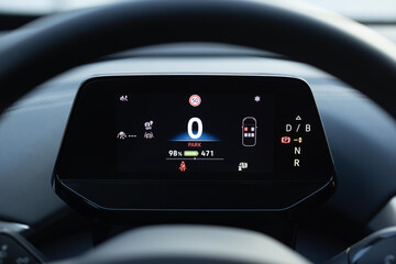 Electric car dashboard view when parked at power charging station. Zero emission car. Long range electric vehicle. Future of cars. Many different car dashboard lights with warning lamps illuminated.
