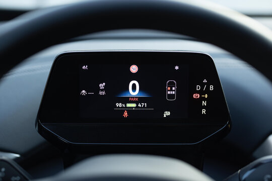 Electric car dashboard view when parked at power charging station. Zero emission car. Long range electric vehicle. Future of cars. Many different car dashboard lights with warning lamps illuminated.