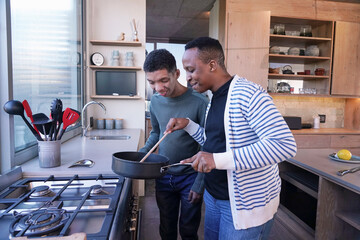 Man and disabled teenage boy cooking together