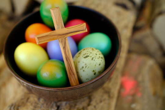 Colored Easter eggs with a wooden cross, for The Resurrection of Christ, most ancient Christian holiday, France - Powered by Adobe