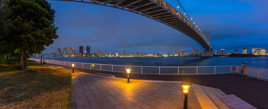 View of the Rainbow Bridge and Koto City in background at dusk, Minato City, Tokyo, Honshu, Japan