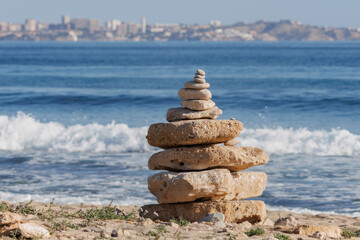 Piedras apiladas en la playa de perros Agua Amarga en Alicante, España