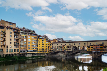 Historic Bridge and Colorful Riverside Buildings Reflected in Calm Water