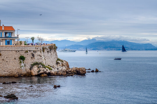 Promenade de Amiral de Grasse, with boats sailing in the Baie des Anges, Antibes, Alpes-Maritimes, French Riviera, France