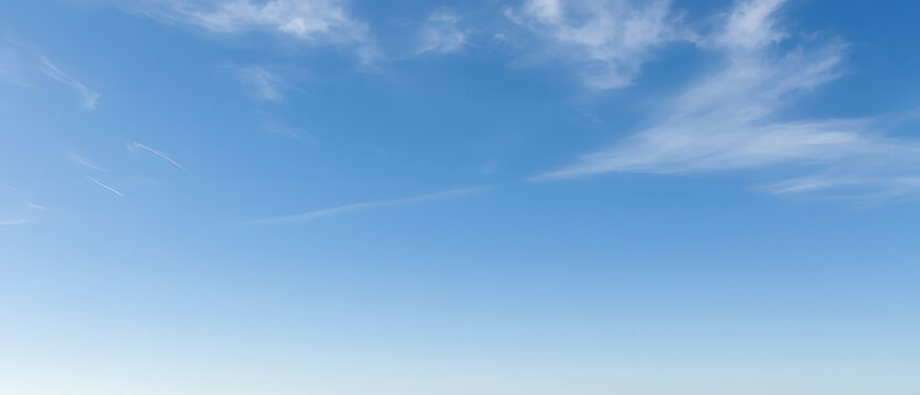 Vast blue sky with wispy cloud trails, dreamy feel