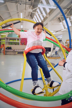 Teenager with down syndrome plying on gyroscope at science center