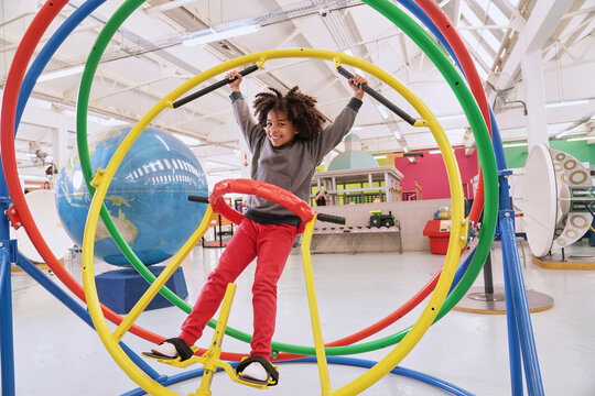 Girl having fun on gyroscope at science center
