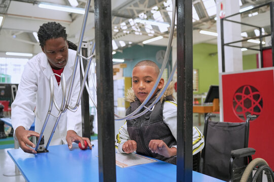 Boy doing experiment with instructor in science center