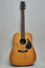 Obraz premium Modern style wooden acoustic guitar isolated on a white background, with metal strings, ideal for Rock music