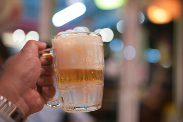 Enjoying a frost cold beer in a frozen mug at a casual gathering during dinner food