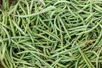 Fresh green beans in container in vegetable market, top view