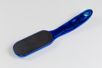 Stainless steel foot scrubber dead skin remover on gray background
