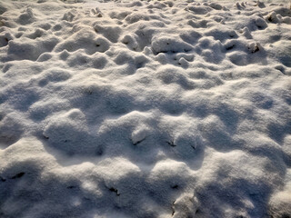 A close-up view of a snow-covered surface with an undulating pattern, capturing the serene beauty of freshly fallen snow. Perfect for winter and nature-themed projects