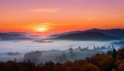 Obraz premium serene sunrise over misty valley with pink and orange skies tranquil landscape of peace and stillness