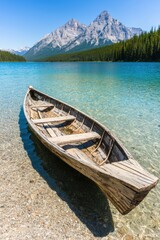 Obraz premium A serene wooden boat rests in clear turquoise waters, surrounded by lush greenery and majestic mountains under a bright blue sky.