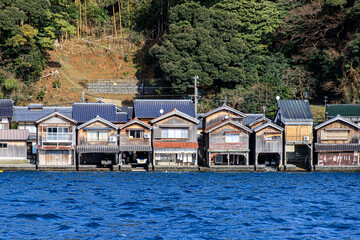 Fototapeta premium Charming Traditional Boat Houses Built Side by Side Along the Waterfront of Ine Bay, Kyoto, Japan