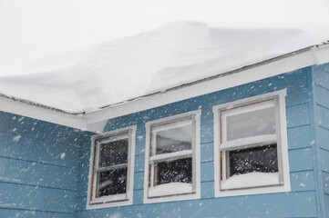 thick snow on the house roof in snow storm