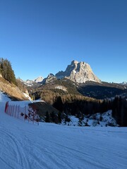Fototapeta premium Panoramic view of the Dolomites mountains in winter, Italy. Santa Fosca Civetta resort.Ski resort in Dolomites, Alps in Italy. Aerial drone view of Santa Fosca ski slopes and mountains in dolomites.