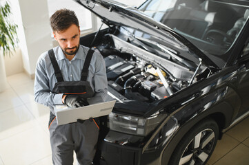 Mechanic Uses a Computer with an Augmented Reality Diagnostics Software. Specialist Inspecting...