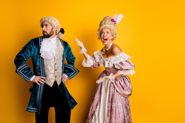 A joyous couple in royal costumes against a yellow background