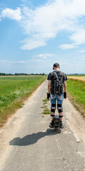 A man is riding a electric unicycle euc on a country road © Lu