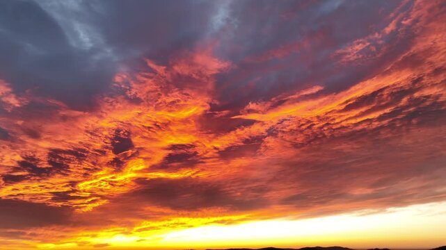 Dramatic colored sunset at sky in american. Flying cloudscape in pink and orange colors. Panorama wide shot in USA:
